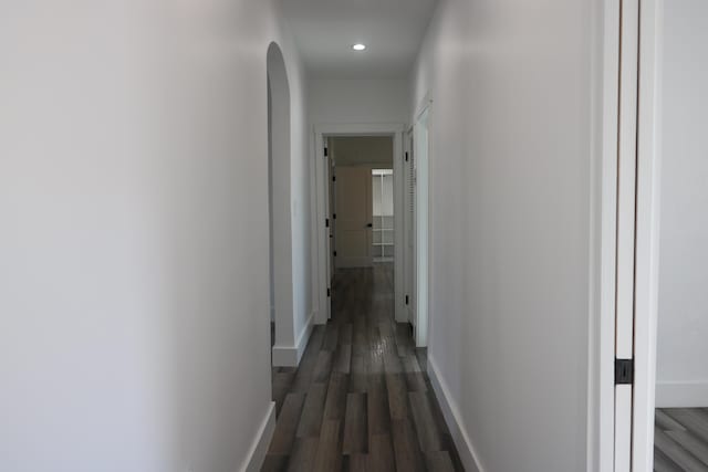 hallway featuring dark wood-style flooring, recessed lighting, and baseboards