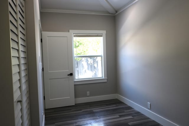 empty room with ornamental molding, dark wood-style flooring, and baseboards