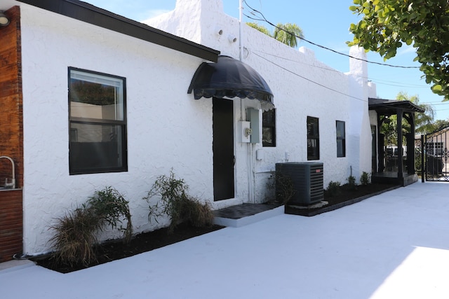 exterior space with cooling unit and stucco siding