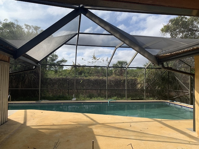 pool with a lanai and a patio area