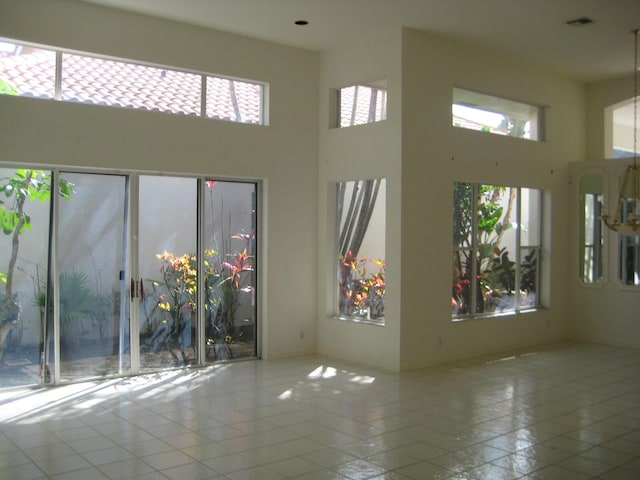 tiled spare room with a high ceiling