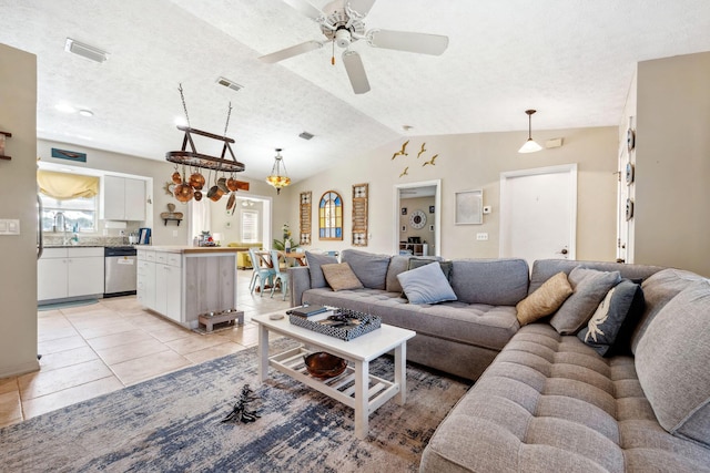 tiled living room featuring ceiling fan, a textured ceiling, and lofted ceiling