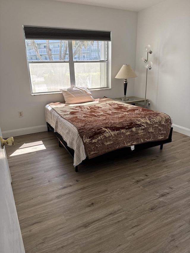 bedroom featuring dark wood-style flooring and baseboards