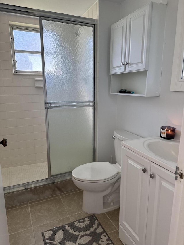 full bathroom featuring a stall shower, vanity, toilet, and tile patterned floors