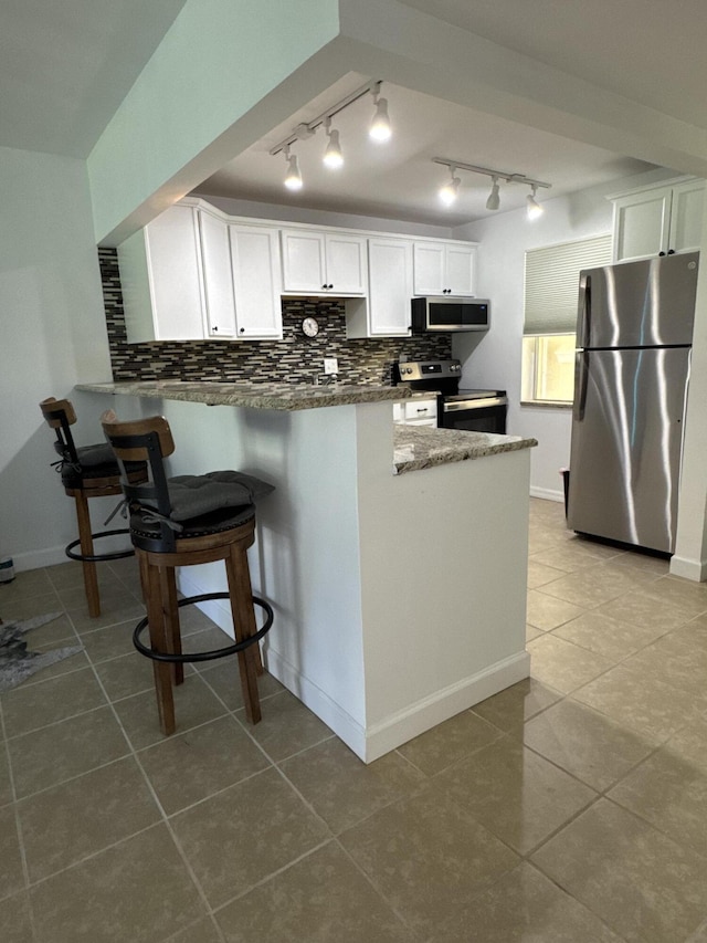 kitchen featuring a peninsula, appliances with stainless steel finishes, backsplash, and white cabinetry