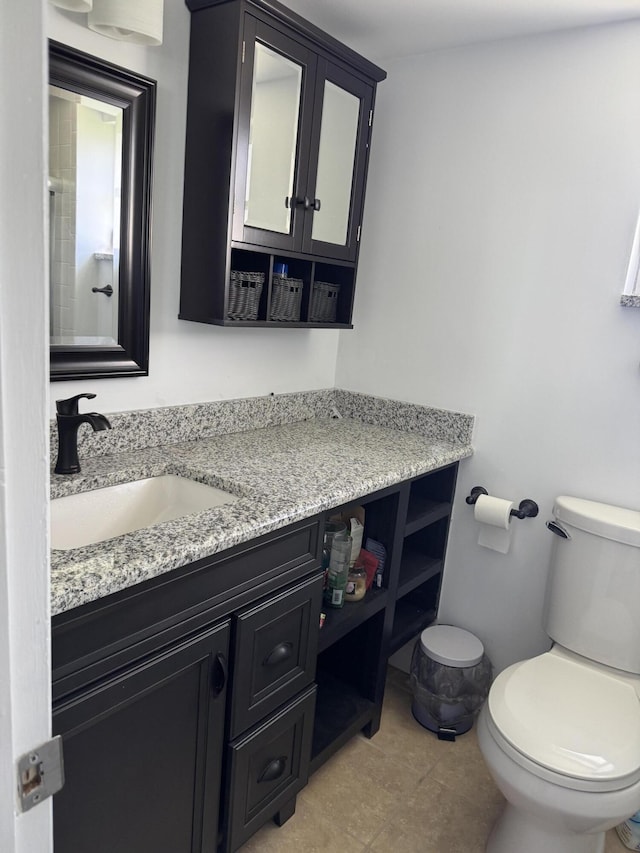 bathroom featuring tile patterned flooring, vanity, and toilet