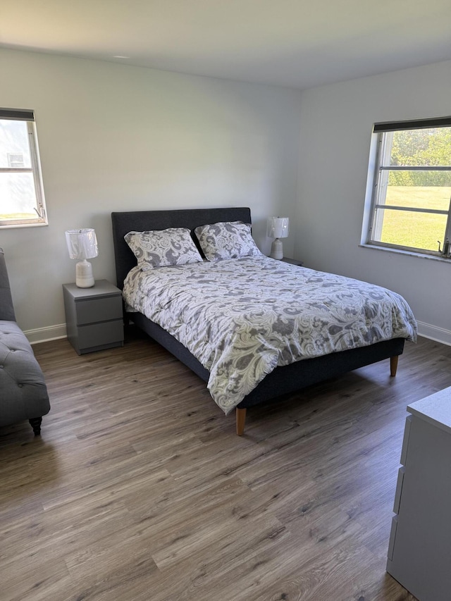 bedroom with baseboards and wood finished floors