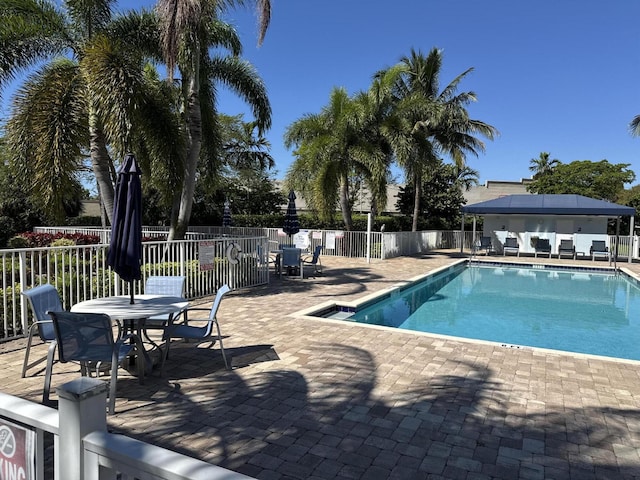 pool with a patio and fence