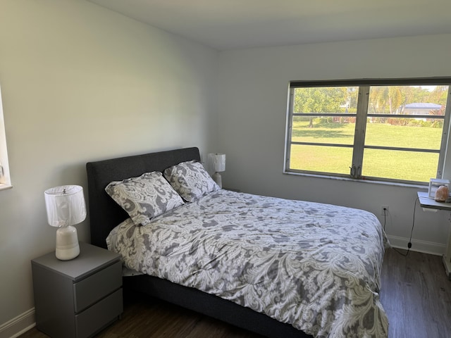 bedroom featuring dark wood-style floors and baseboards