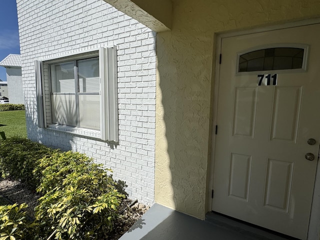 entrance to property with brick siding and stucco siding