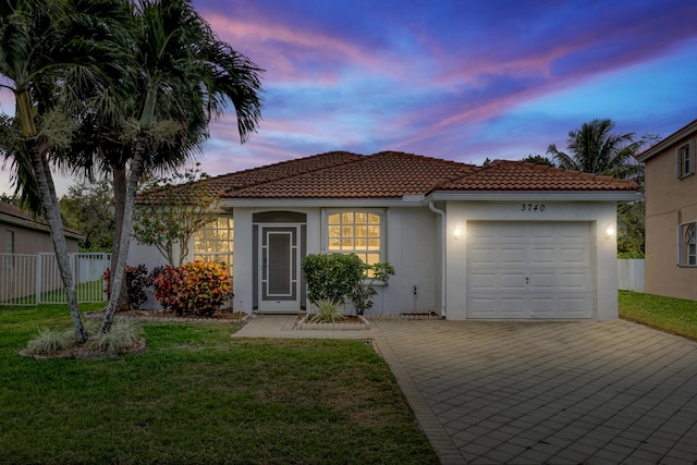 view of front of house featuring a garage and a lawn