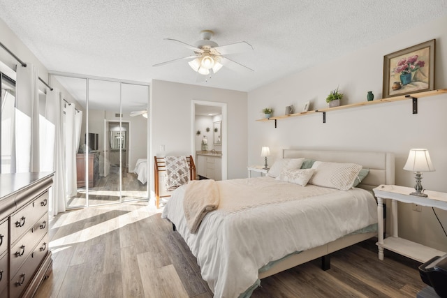 bedroom featuring a textured ceiling, a closet, hardwood / wood-style flooring, and ensuite bath