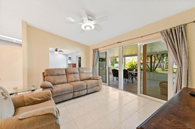 living room featuring lofted ceiling, light tile patterned floors, and ceiling fan