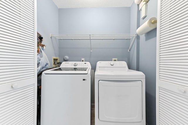 laundry area featuring a textured ceiling, laundry area, and washing machine and clothes dryer