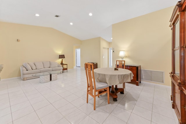 dining area featuring visible vents, light tile patterned flooring, and vaulted ceiling