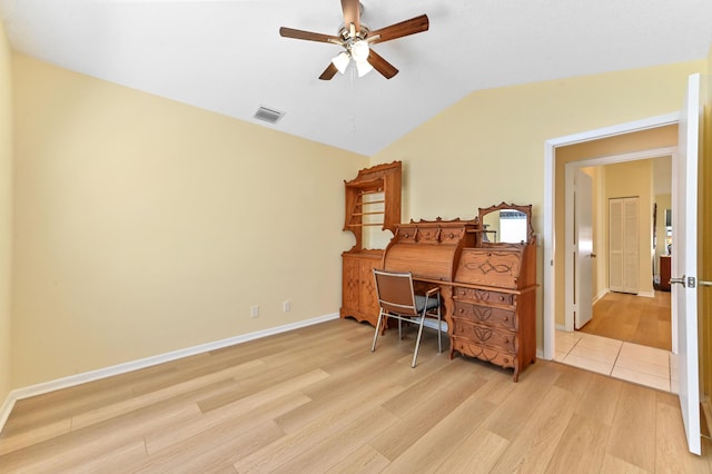 office space featuring visible vents, baseboards, vaulted ceiling, light wood-style floors, and a ceiling fan