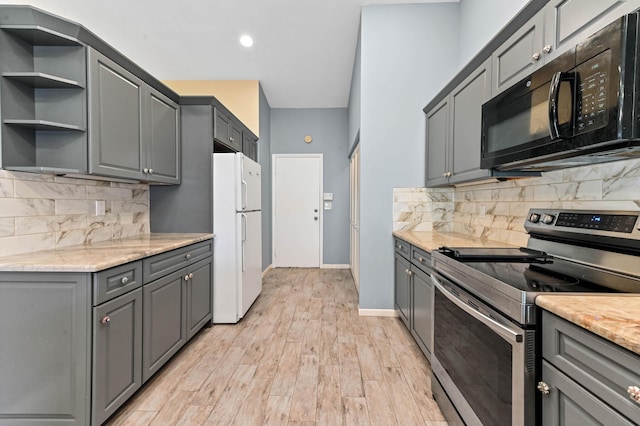 kitchen with stainless steel range with electric stovetop, light wood-style flooring, gray cabinets, freestanding refrigerator, and black microwave