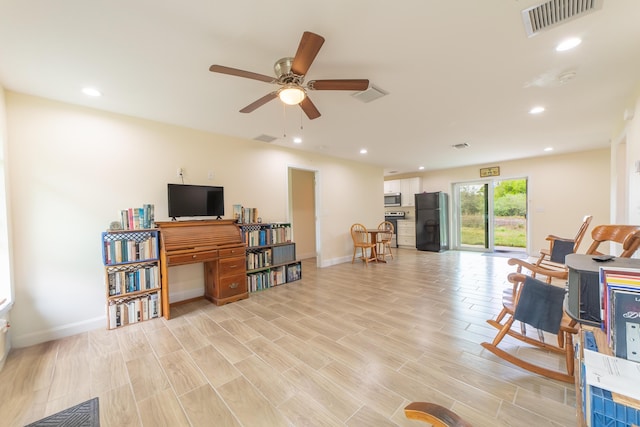 sitting room with light hardwood / wood-style floors and ceiling fan