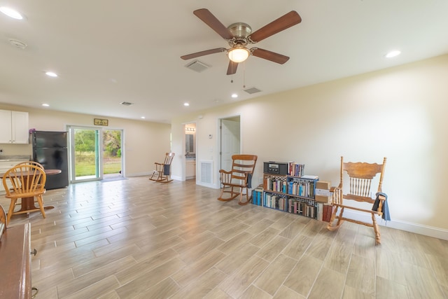 living area featuring light wood-type flooring and ceiling fan