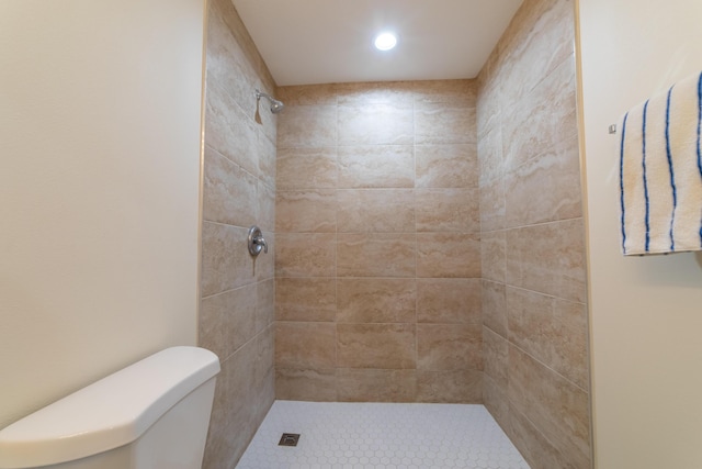 bathroom with toilet and tiled shower