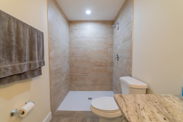 bathroom with a tile shower and toilet