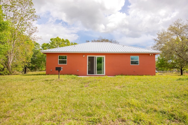 back of house with a lawn