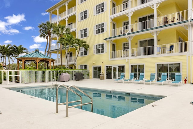 pool with a gazebo, a patio area, and fence