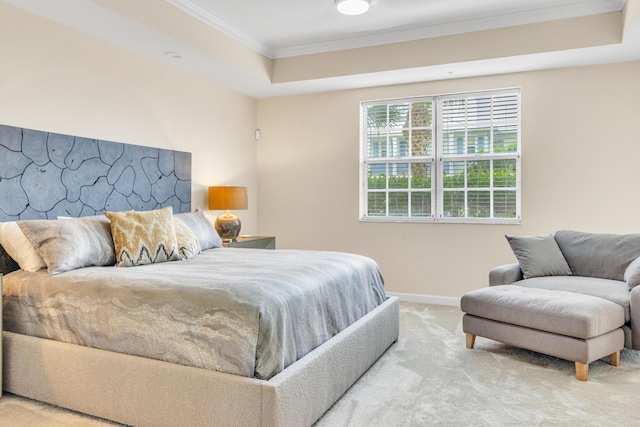 carpeted bedroom with ornamental molding, a raised ceiling, and baseboards