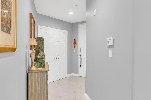 hall featuring recessed lighting, marble finish floor, and baseboards