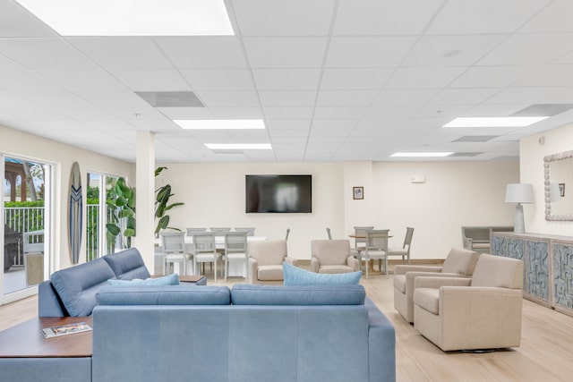 living area featuring light wood-type flooring and a paneled ceiling