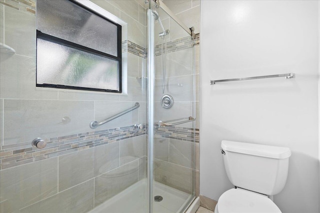 bathroom with toilet and an enclosed shower