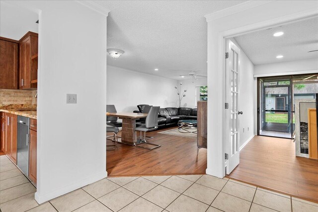 interior space featuring light tile patterned flooring, plenty of natural light, ceiling fan, and a textured ceiling