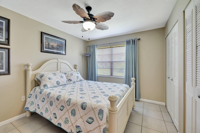 2050 Oleander Blvd Unit 1106, Fort Pierce, FL 34950 - bedroom featuring light tile patterned flooring, multiple closets, baseboards, ceiling fan, and a textured ceiling