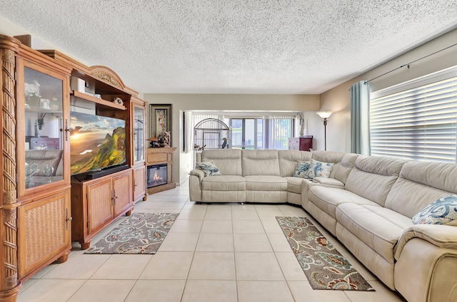 2050 Oleander Blvd Unit 1106, Fort Pierce, FL 34950 - living area with light tile patterned flooring, a textured ceiling, and a glass covered fireplace