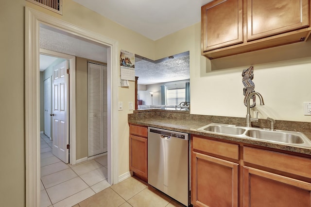 2050 Oleander Blvd Unit 1106, Fort Pierce, FL 34950 - kitchen featuring dishwasher, a sink, light tile patterned flooring, dark countertops, and brown cabinetry