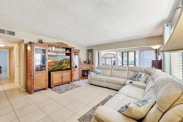 2050 Oleander Blvd Unit 1106, Fort Pierce, FL 34950 - living area featuring a textured ceiling, light tile patterned flooring, and a lit fireplace