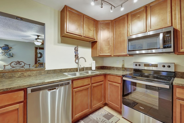 2050 Oleander Blvd Unit 1106, Fort Pierce, FL 34950 - kitchen with appliances with stainless steel finishes, a sink, brown cabinetry, a ceiling fan, and light tile patterned floors