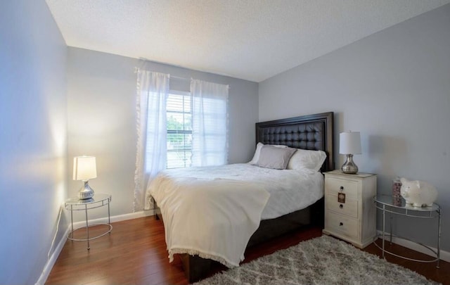 bedroom with dark wood-type flooring and a textured ceiling