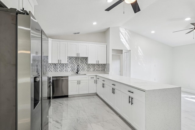 kitchen with white cabinets, sink, stainless steel appliances, and kitchen peninsula