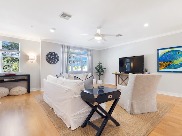 living room featuring light hardwood / wood-style floors, ceiling fan, and ornamental molding