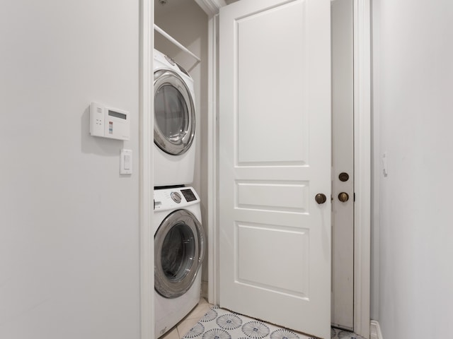 washroom with stacked washer / drying machine and light tile patterned floors