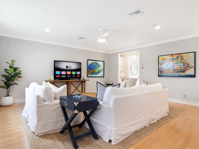 living room with light wood-type flooring, crown molding, and ceiling fan