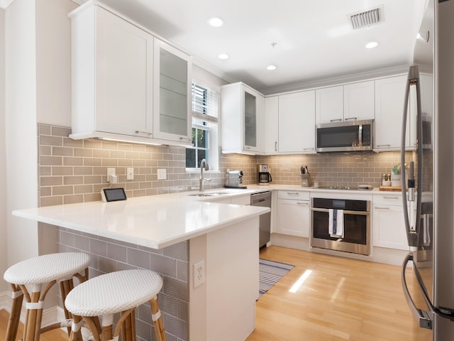 kitchen featuring a peninsula, appliances with stainless steel finishes, and a kitchen breakfast bar