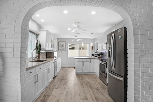 2144 NE 63rd St, Fort Lauderdale, FL 33308 - kitchen with stainless steel appliances, white cabinets, a sink, and light wood finished floors