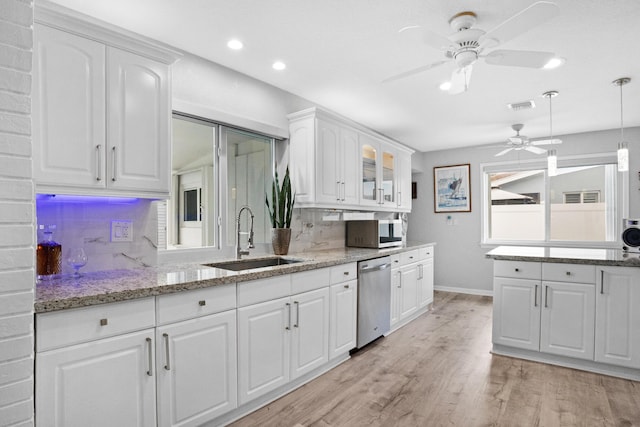 2144 NE 63rd St, Fort Lauderdale, FL 33308 - kitchen featuring tasteful backsplash, hanging light fixtures, stainless steel appliances, white cabinetry, and a sink
