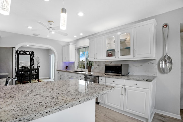 2144 NE 63rd St, Fort Lauderdale, FL 33308 - kitchen featuring arched walkways, decorative light fixtures, stainless steel appliances, glass insert cabinets, and white cabinetry