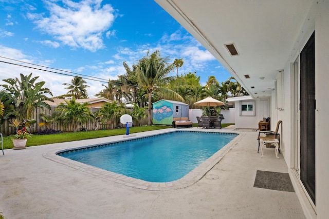 2144 NE 63rd St, Fort Lauderdale, FL 33308 - view of swimming pool featuring an outbuilding, a patio area, a fenced backyard, and a storage unit