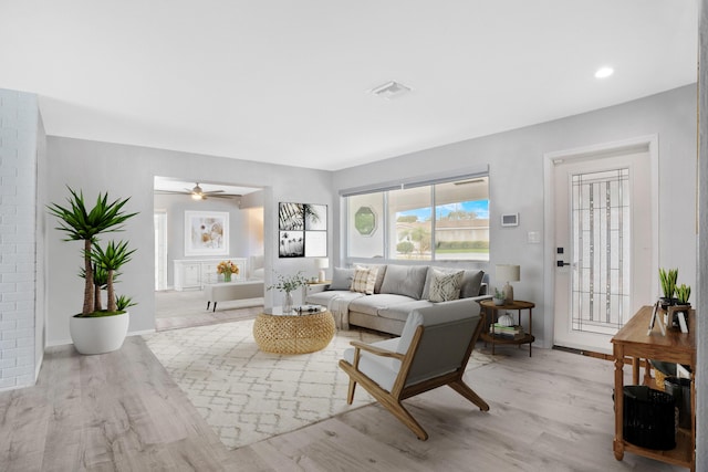 living area with recessed lighting, visible vents, light wood-style flooring, a ceiling fan, and baseboards