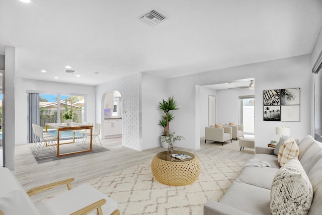 2144 NE 63rd St, Fort Lauderdale, FL 33308 - living area with arched walkways, light wood-style flooring, visible vents, and a ceiling fan