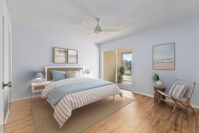 bedroom featuring access to exterior, baseboards, light wood-style flooring, and a textured ceiling